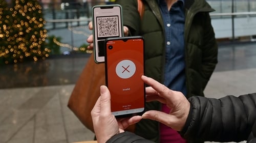 A restaurant manager checks a customer's Covid pass using the Covid Cert NI app in Belfast (File image)