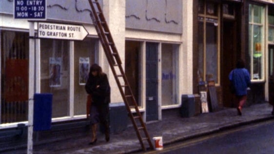 A woman walks under a ladder in Dublin city centre, 1987.