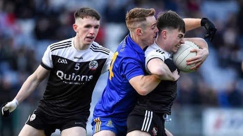 Eoin McGreevey of St Finbarr's attempts to dispossess Kilcoo's Ceilum Doherty