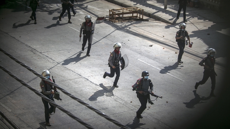 Police run towards protesters to disperse a demonstration being held against the military coup