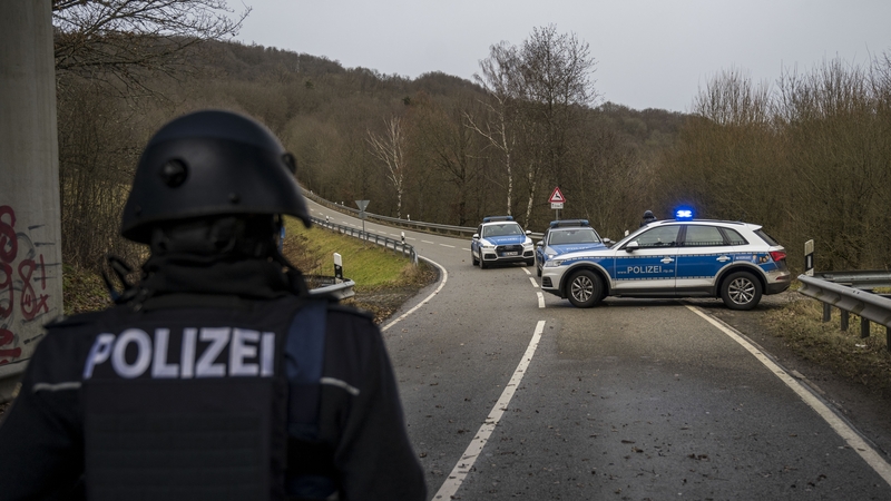 Police officers block a road leading to the scene of the shooting that left two police officers dead