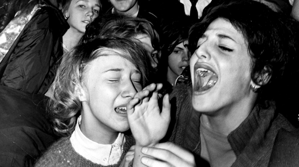 Fans lose it as they await the arrival of the Beatles at Kennedy Airport in New York on February 7, 1964. (Photo by Getty)