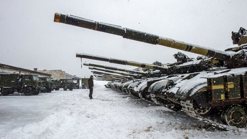 An Ukrainian Military Forces serviceman stands in front of tanks in the Kharkiv region