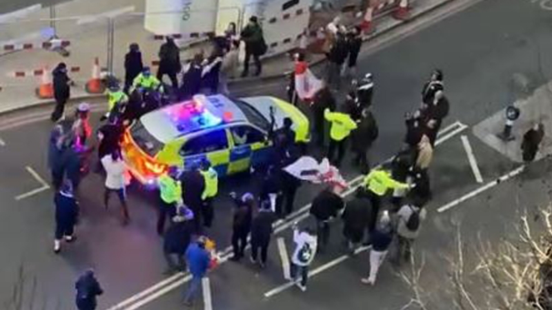 Keir Starmer is escorted away by a police vehicle, surrounded by protesters