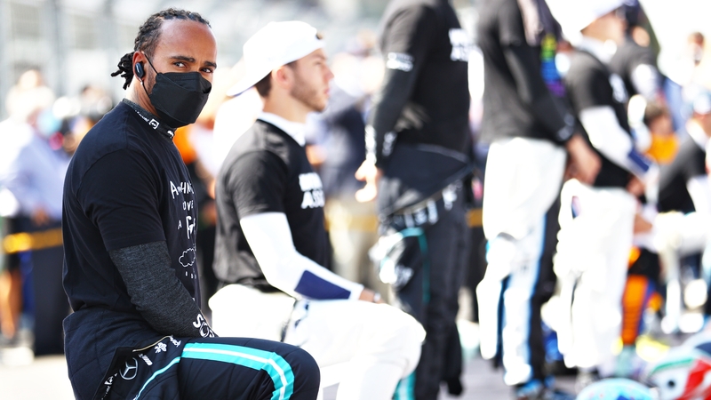 Lewis Hamilton (L) takes a knee before the Grand Prix of Mexico last November.