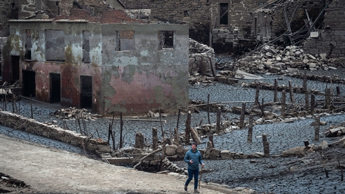A man walks through the formerly submerged village of Aceredo