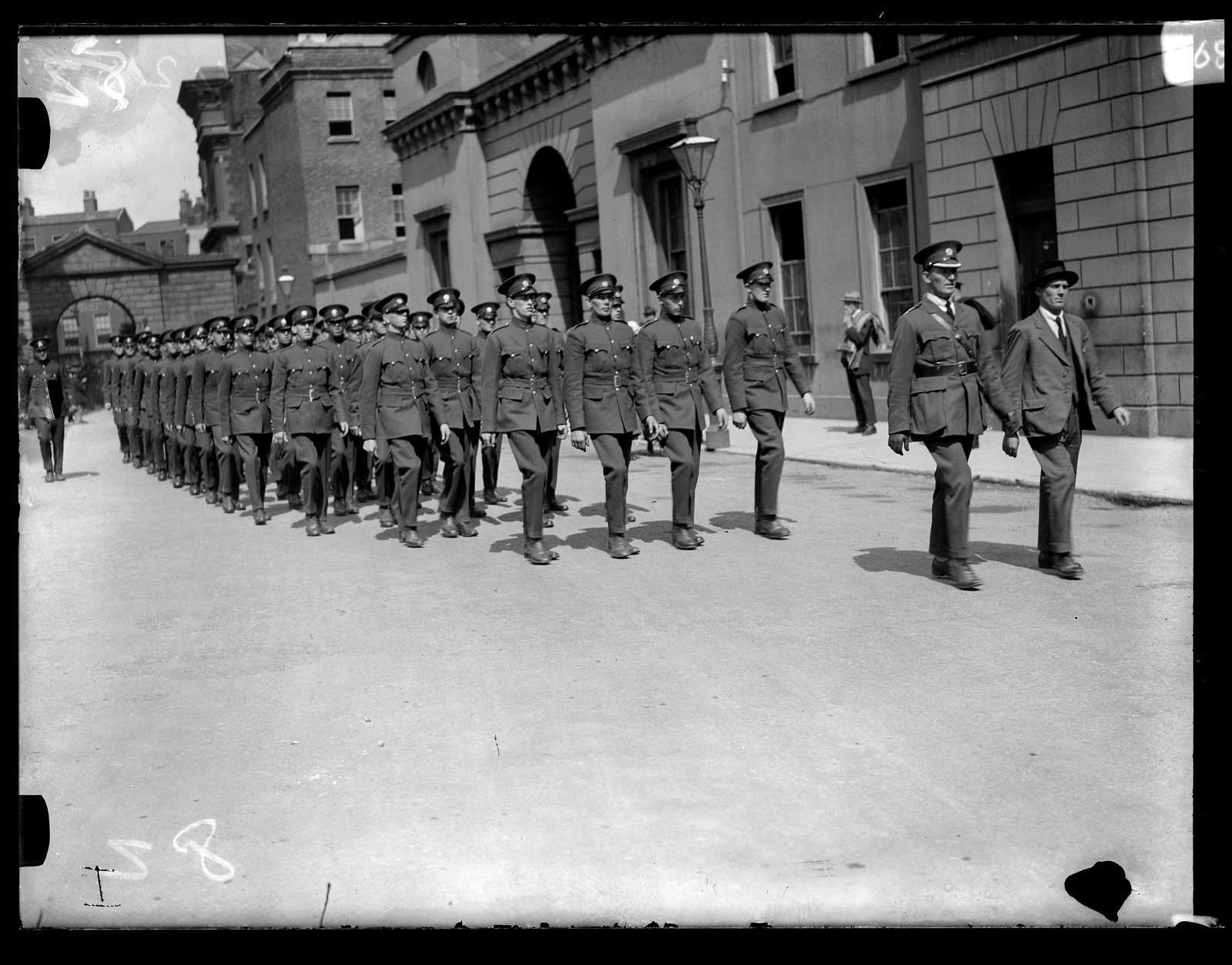The Civic Guard march into Dublin Castle, led by Commissioner Michael Staines. He is in civilian clothes; this was his last act before resignation. Image: Cashman Collection, RTÉ Archive