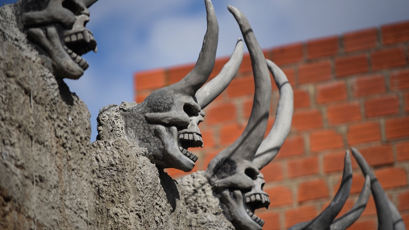 An artist was hired to create the skeletal devils from cement and wood