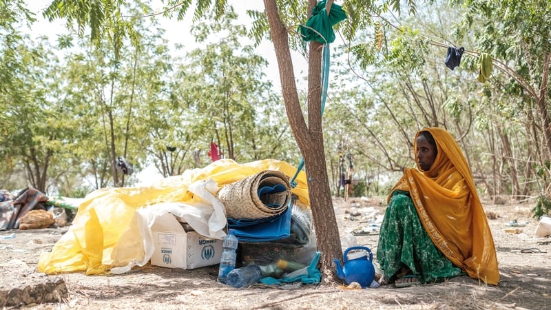 A woman seats next to her belongings in the Agda Hotel compound in Semera, Ethiopia, which hosts hundreds of civilians fleeing violence