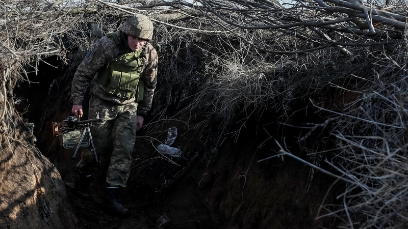 A Ukrainian service member walks along a trench at a position on the front line near the village of Travneve in Donetsk region