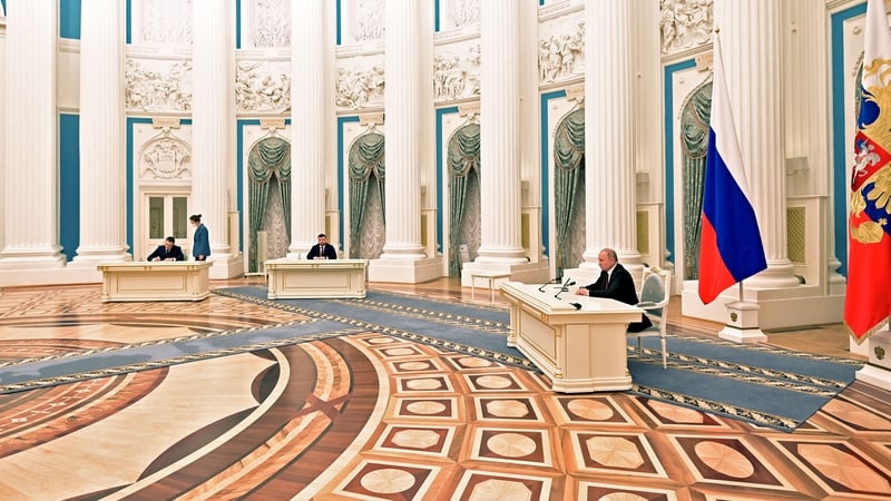Vladimir Putin (R) attends a ceremony to sign documents, including a decree recognising two Russian-backed breakaway regions in eastern Ukraine