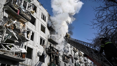 Firefighters work on a fire on a building after bombings on the eastern Ukraine town of Chuguiv