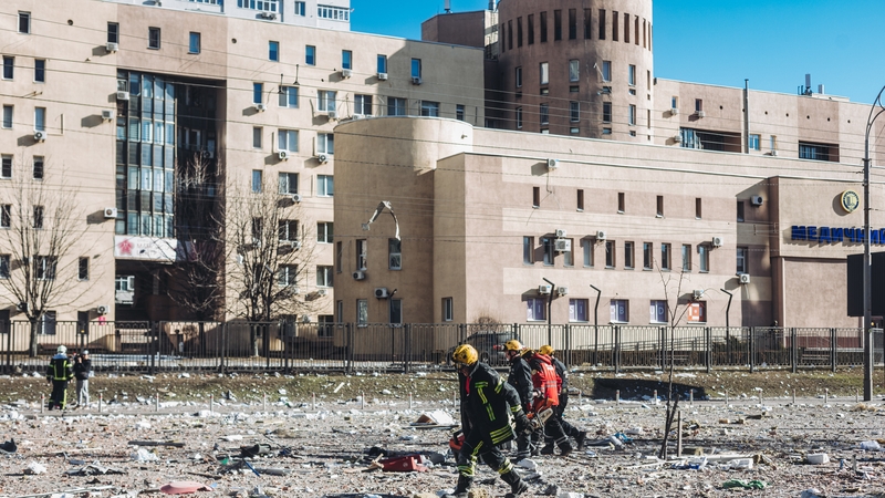 Firefighters and emergency services in the vicinity of a bombed civilian building in Kyiv