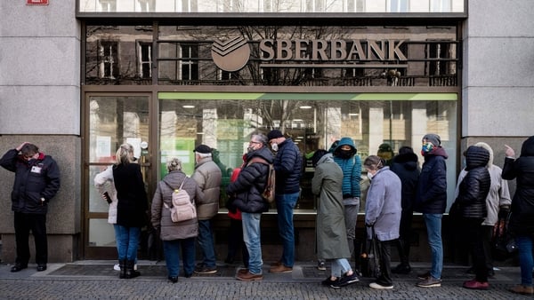 People queue outside a branch of Russian state-owned bank Sberbank to withdraw their savings and close their accounts in Prague