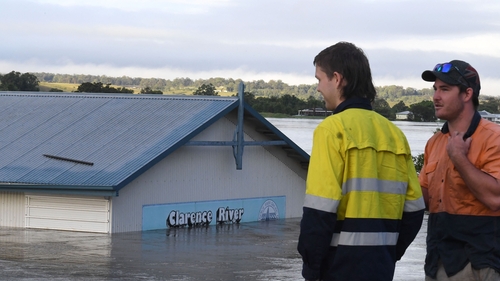 Workers watch a flooded shed at the bank of over flowing Clarence River in New South Wales on 1 March