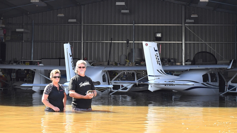 Flying instructor Peter Clement and his wife Kerrie inspect their aircraft inside a hanger after a flood inundated Grafton Air Strip in Grafton