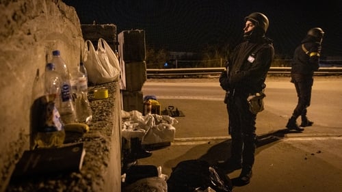 Members of a territorial defence unit guard a barricade close to the eastern frontline in Kyiv, Ukraine this evening