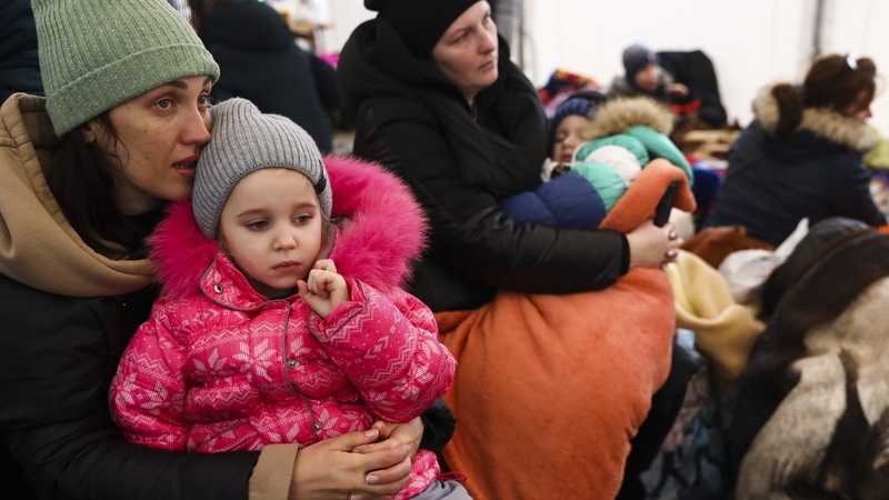 Woman and children wait at the border with Poland in Medyka
