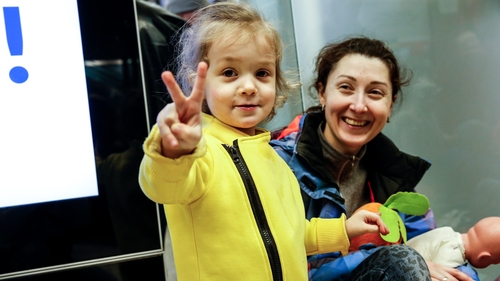 A Ukrainian refugee child shows victory signs after arriving in Krakow. Over one million have already fled into Poland from Ukraine