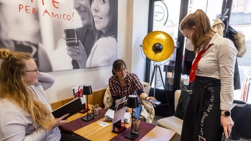A woman shows her Covid vaccine pass in a restaurant in Innsbruck, Austria