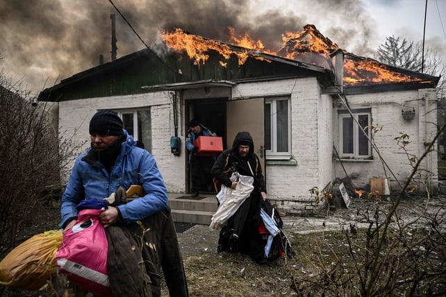 People try to save their belongings after shelling in Irpin on 9 March