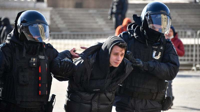 Police officers detain a man during a protest in Moscow against Russian military action in Ukraine