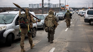 Ukrainian servicemen carry rocket-propelled grenades and sniper rifles near Irpin, where a US journalist died today