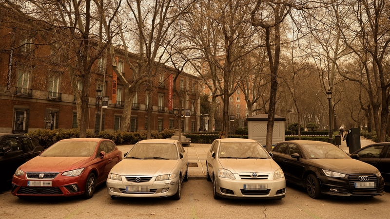 A line of vehicles covered in dust in Madrid, Spain