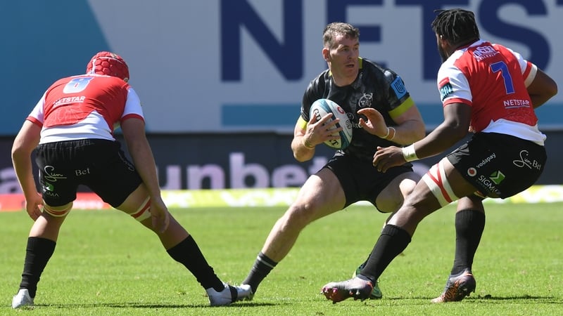 Chris Farrell of Munster tries to evade a pair of Lions