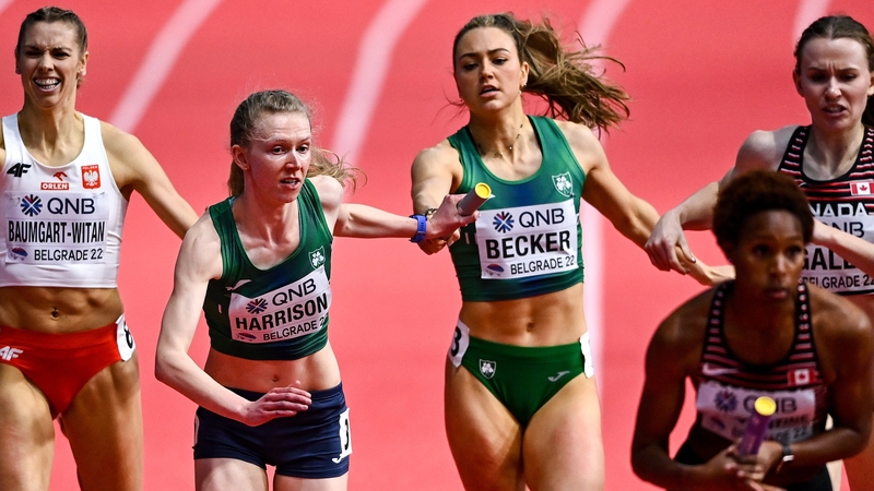 Roisin Harrison of Ireland, centre left, takes the baton from team-mate Sophie Becke