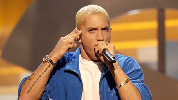 Eminem wearing a blue shirt over a white t-shirt