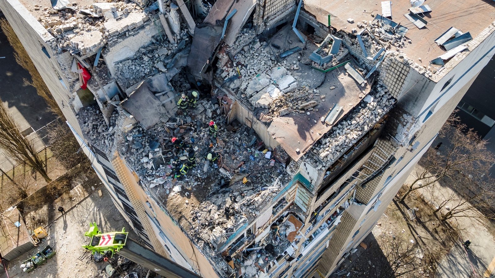 Firefighters work in the rubble of a residential building which was hit by debris from a downed rocket in Kyiv