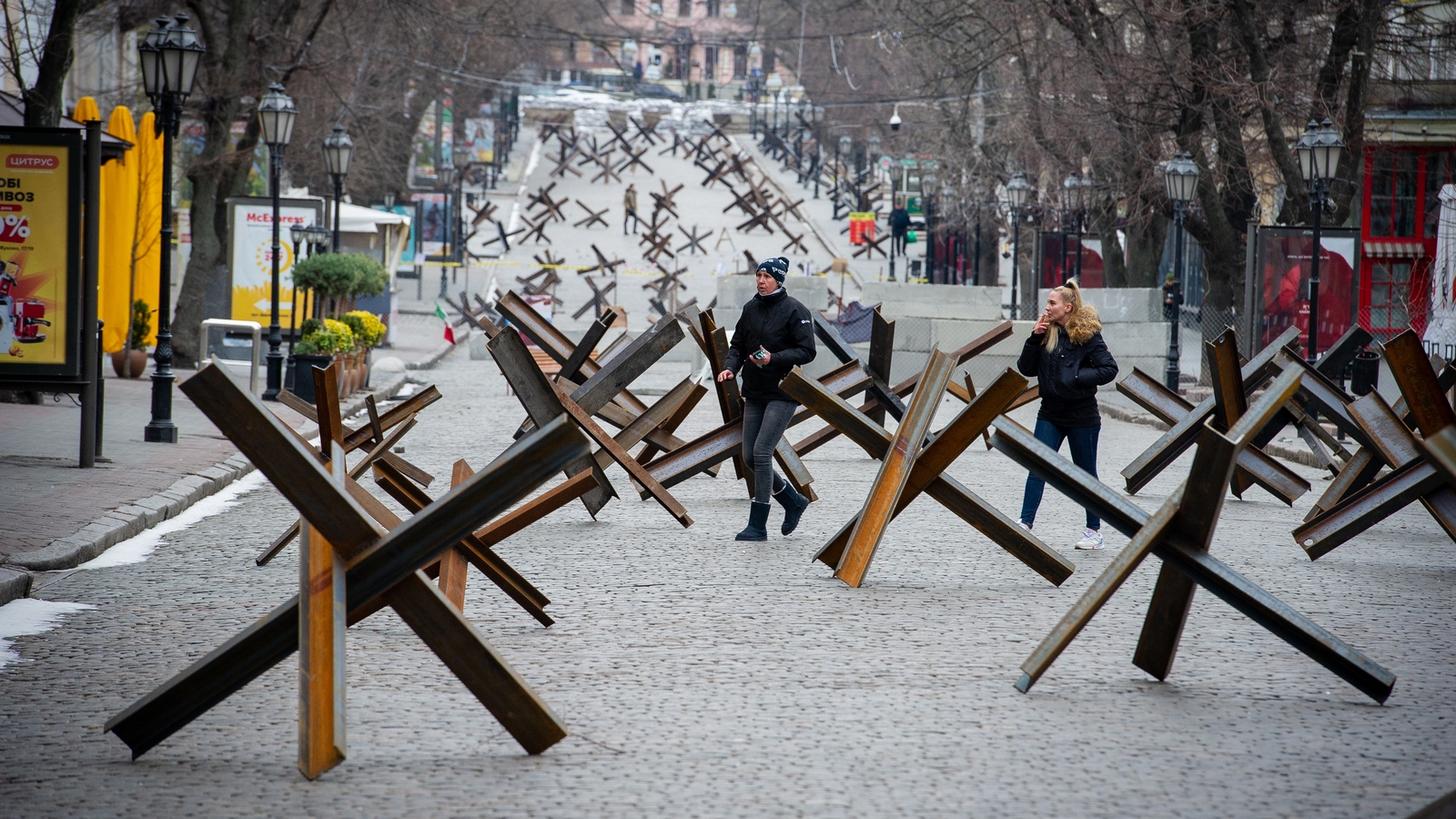 People walk among anti-tank barriers placed to protect historic landmarks in expectation of a Russian assault on the strategic Black Sea port city of Odessa