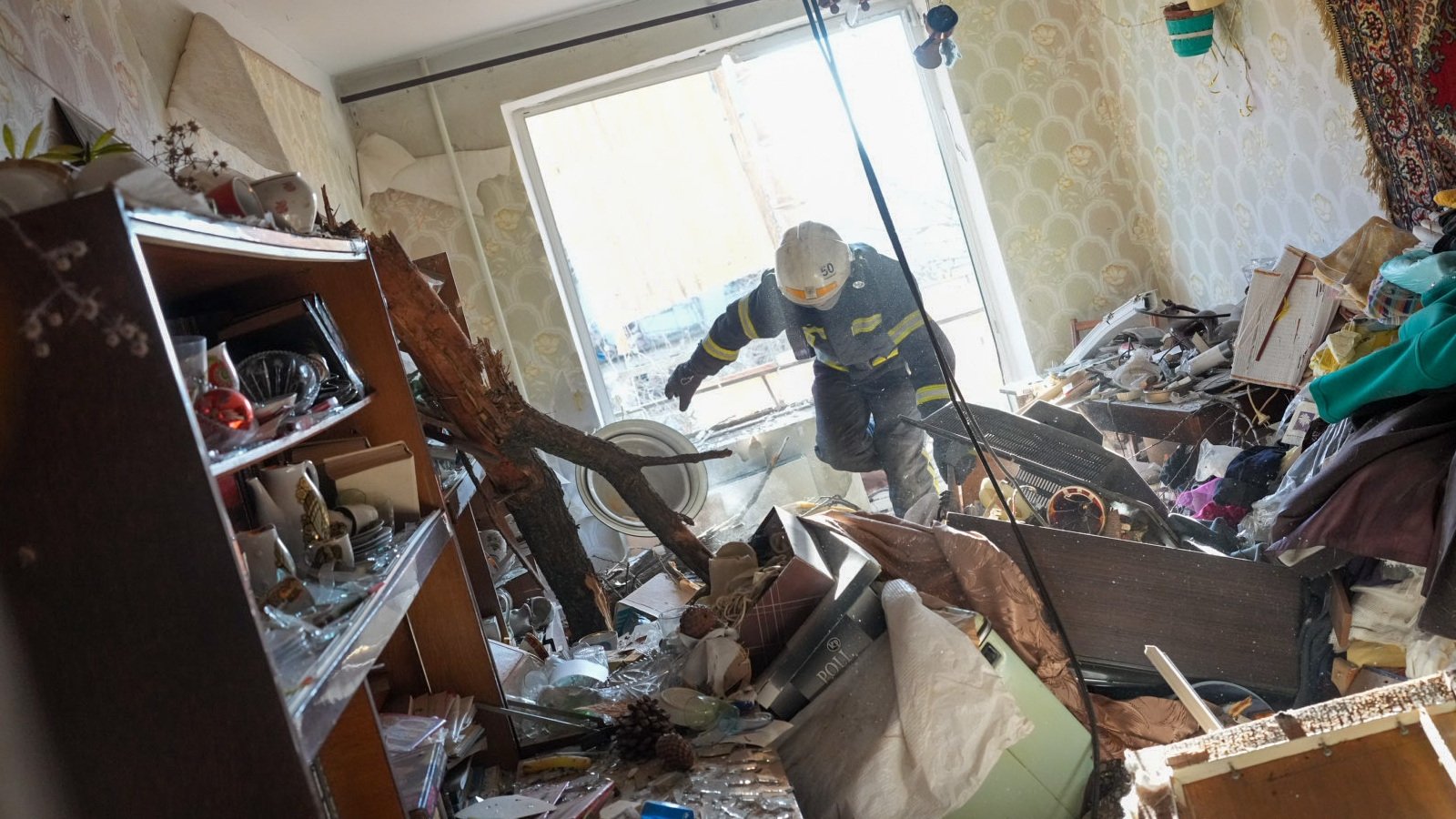 Firefighters arrive to rescue civilians after an airstrike hit an apartment complex in Chuhuiv, Kharkiv