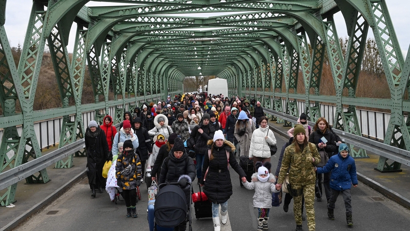 Ukrainian refugees walk a bridge at the buffer zone with the border with Poland in the border crossing of Zosin-Ustyluh, western Ukraine
