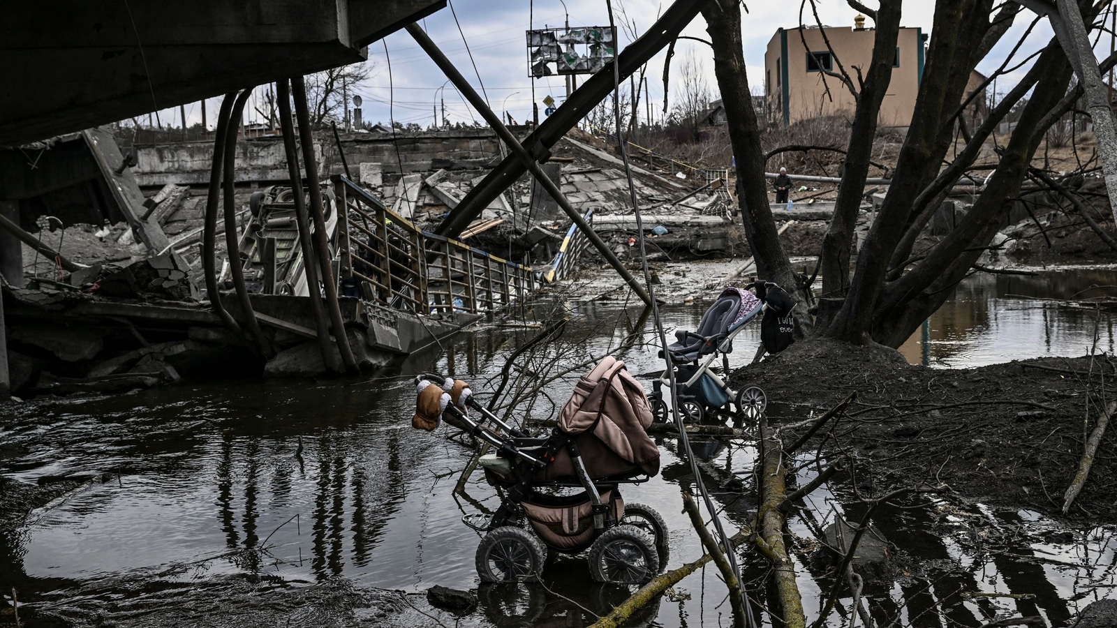 Abandoned strollers under a destroyed bridge as people flee the city of Irpin