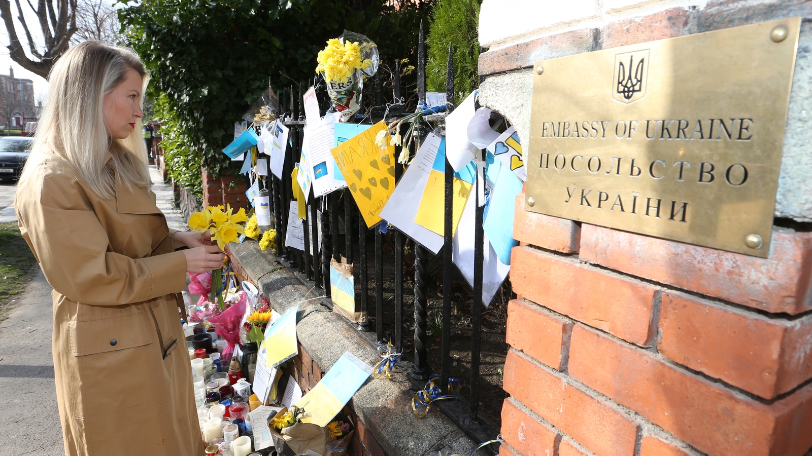 A woman looks at flowers and messages of support for the people of Ukraine outside the Ukraine embassy in Dublin (Pic: RollingNews.ie)