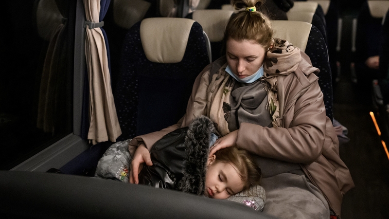 A Ukrainian refugee holds her sleeping child after landing in Switzerland on Tuesday