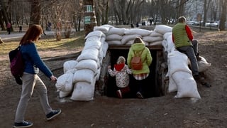 People walk down the sandbagged entrance to a bomb shelter after air raid sirens sounded in Lviv, Ukraine today