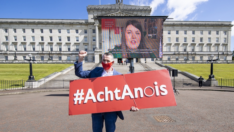 Declan Kearney MLA for Sinn Féin pictured at Stormont in May, 2021 with an 'Act Now' sign supporting Irish language
