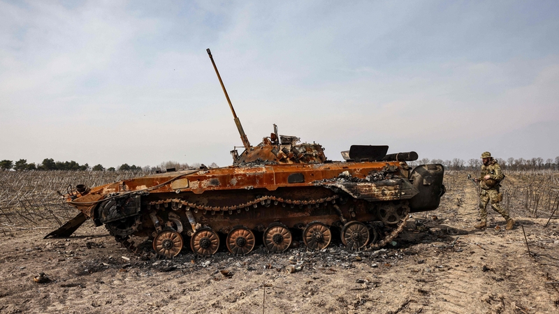 Saighdiúirí Úcránacha taobh le tanc dóite le hArm na Rúise