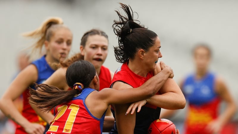Sinead Goldrick of the Demons is tackled by Courtney Hodder of the Lions