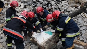 Rescuers clear debris at the site of a multi-storey residential building destroyed by Russian shelling in Borodyanka