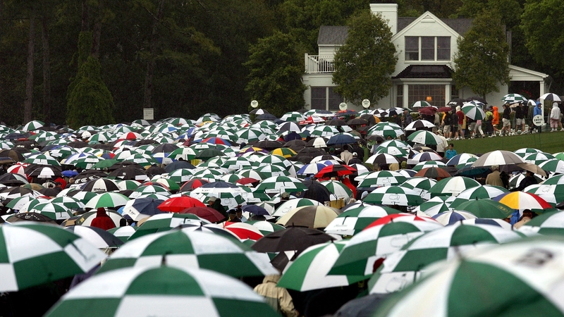 Patrons carry umbrellas along the course at Augusta