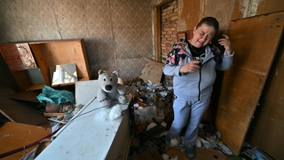 A woman looks distressed inside her destroyed house on the outskirts of Ivankiv in northern Ukraine today