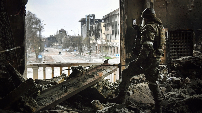 A Russian soldier patrols at the Mariupol drama theatre, bombed on 16 March