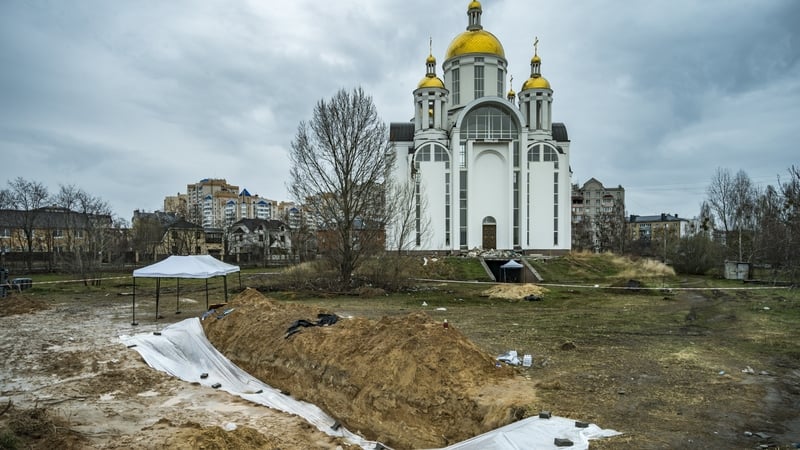 A mass grave in Bucha is covered by a plastic sheet