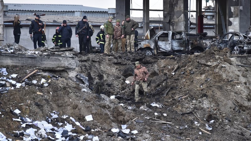 Soldiers inspect the crash site of a Russian missile that hit a car service station in Lviv