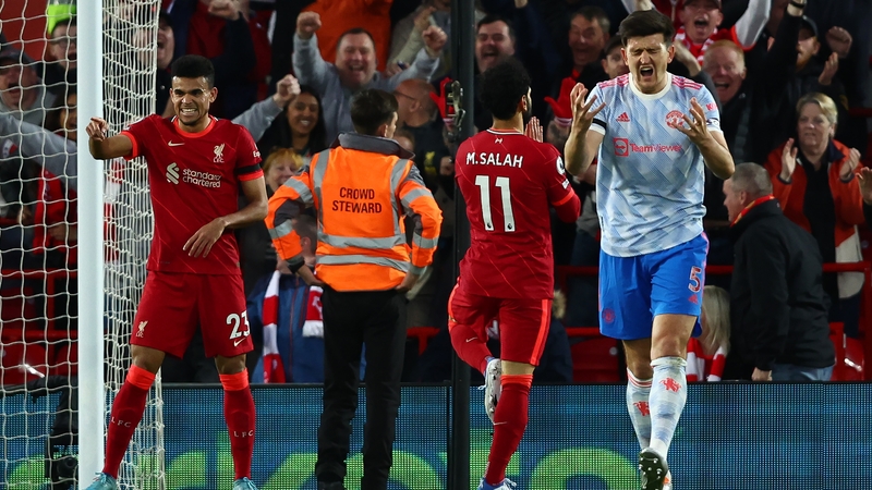 Harry Maguire reacts as Mo Salah celebrates Liverpool's second goal at Anfield
