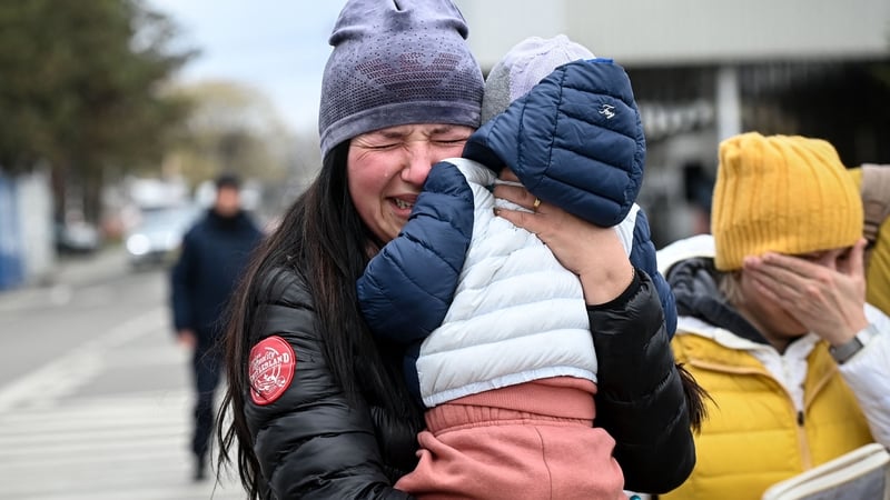 A Ukrainian refugee holding her child cries after she arrived at the Siret border crossing between Romania and Ukraine on 18 April